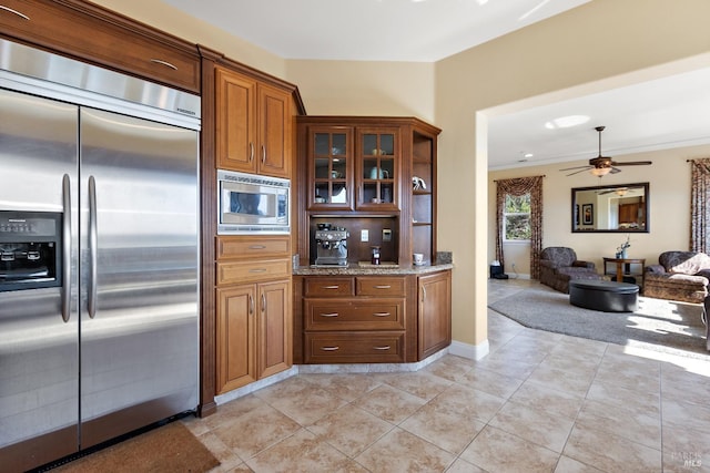 kitchen with light tile patterned flooring, built in appliances, and ceiling fan