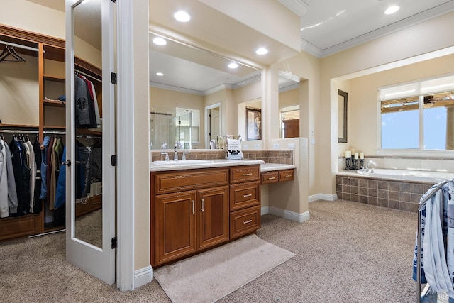 bathroom with a relaxing tiled tub, ornamental molding, and vanity