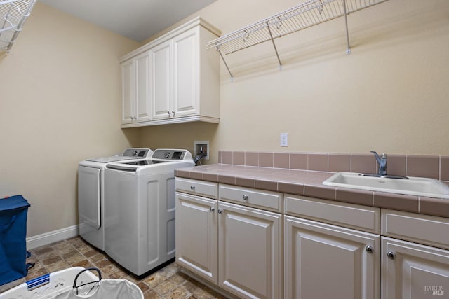 laundry room with cabinets, sink, and washer and dryer