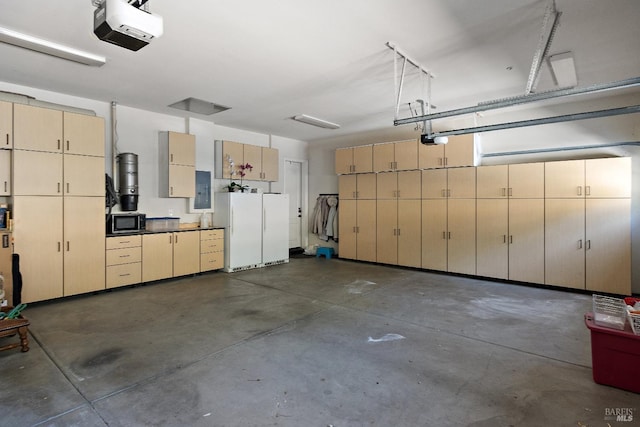 garage with a garage door opener, electric panel, and white fridge