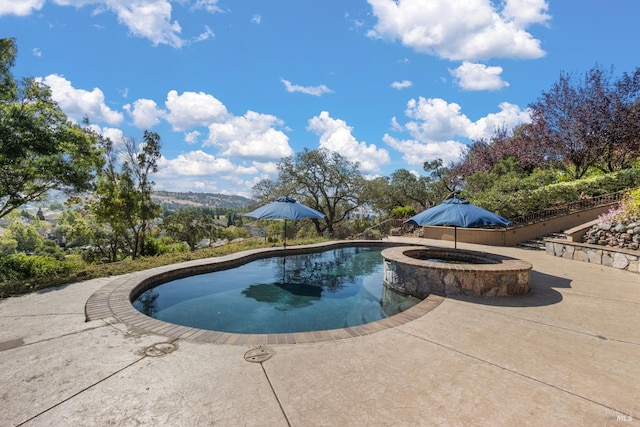 view of pool featuring an in ground hot tub and a patio