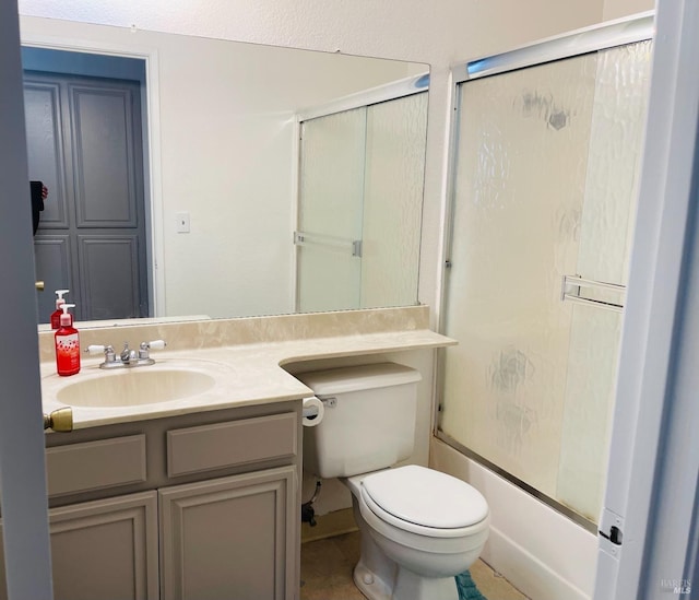 bathroom with vanity, combined bath / shower with glass door, and toilet