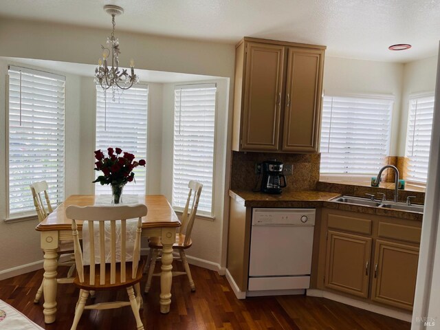 kitchen with dishwasher, a sink, baseboards, an inviting chandelier, and dark wood-type flooring