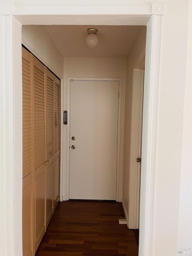 corridor featuring dark wood-style flooring