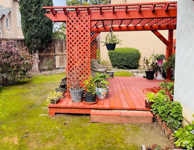 wooden terrace with a lawn, fence, and a pergola