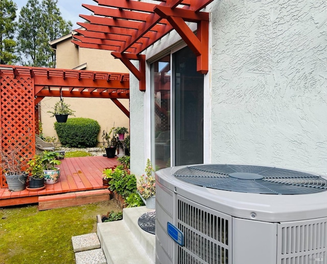 details featuring a hot tub, central AC, and stucco siding