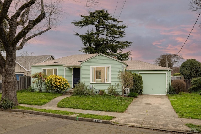 view of front of property with a garage and a lawn