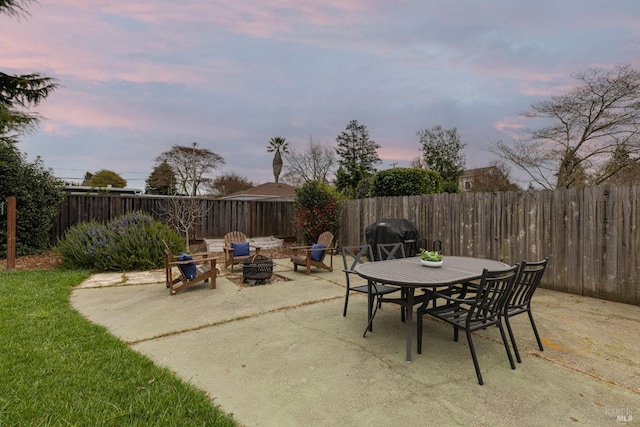 patio terrace at dusk featuring an outdoor fire pit and area for grilling