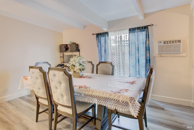 dining room featuring beamed ceiling, wood finished floors, an AC wall unit, and baseboards