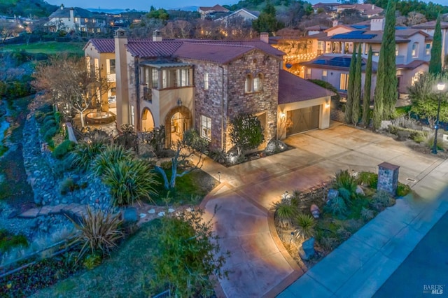 mediterranean / spanish-style house featuring a garage, concrete driveway, and a chimney