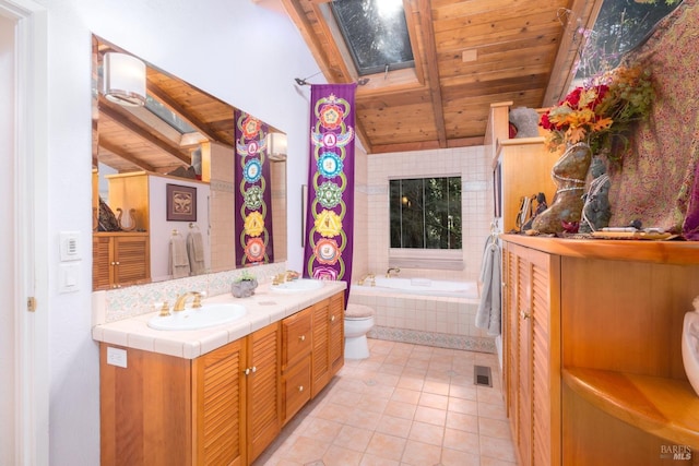 bathroom with tiled tub, tile patterned floors, wooden ceiling, vanity, and lofted ceiling with skylight