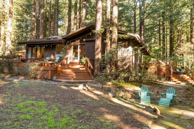 rear view of house featuring a wooden deck