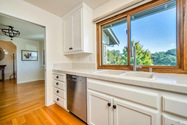 kitchen with white cabinets, dishwasher, and tile counters