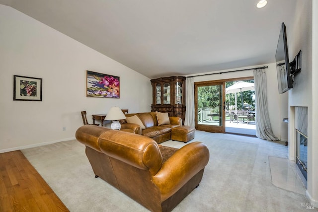 carpeted living room with a fireplace and vaulted ceiling