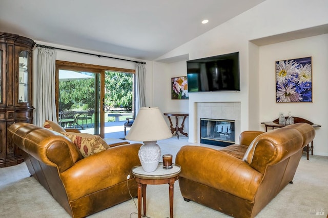 living room featuring a tiled fireplace, lofted ceiling, and light carpet