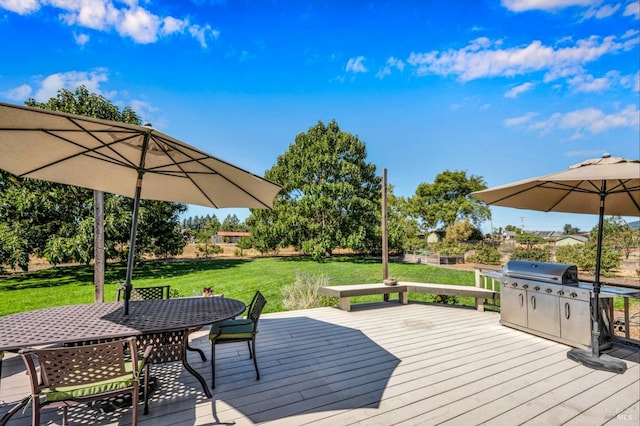 wooden deck featuring a lawn and a grill