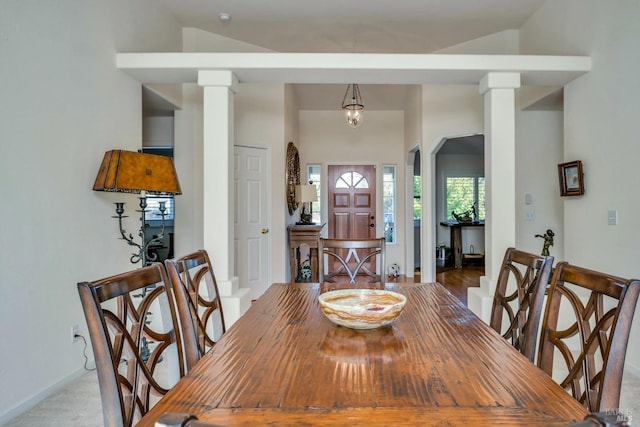 carpeted dining space with decorative columns