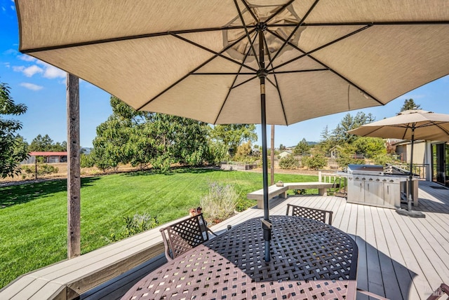 deck featuring a yard and grilling area