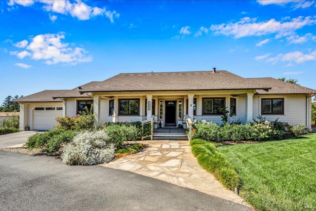 ranch-style home with a front lawn, a garage, and covered porch