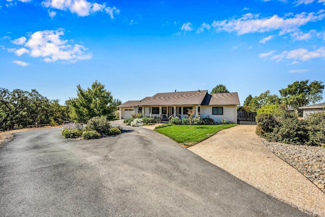 ranch-style house featuring a front lawn and a garage