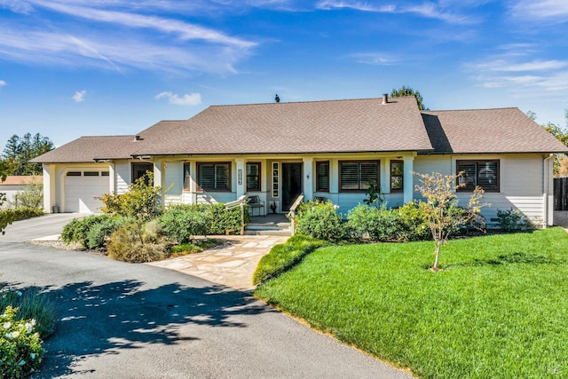 ranch-style home with covered porch, a garage, and a front lawn