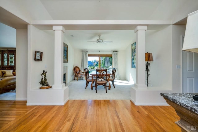 dining area featuring ceiling fan, light hardwood / wood-style floors, decorative columns, and lofted ceiling