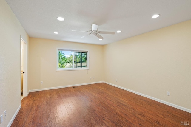 empty room with recessed lighting, wood finished floors, a ceiling fan, and baseboards