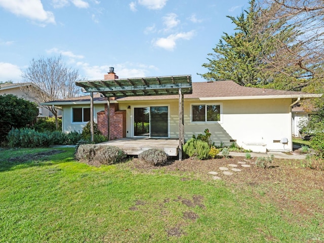 rear view of property with crawl space, a chimney, a lawn, and stucco siding