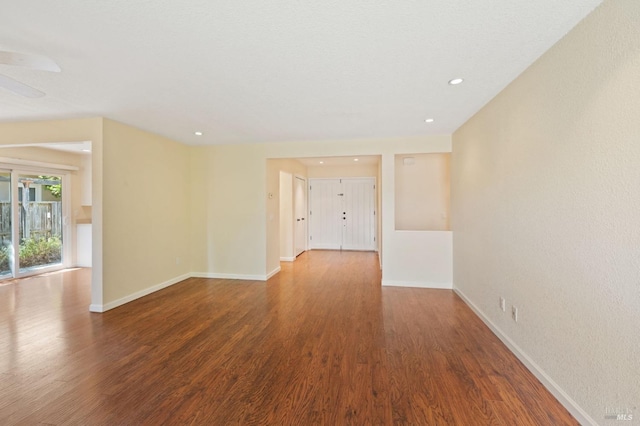 unfurnished room with recessed lighting, wood finished floors, and baseboards