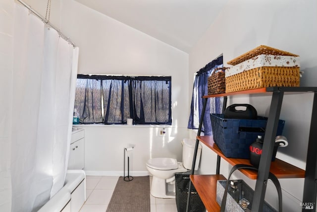 bathroom with tile patterned floors, toilet, and lofted ceiling