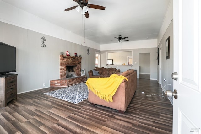 living room with dark hardwood / wood-style flooring, ceiling fan, and a fireplace