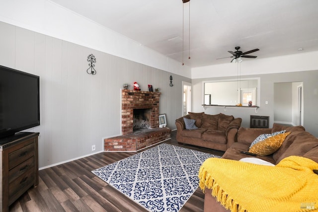 living room with dark hardwood / wood-style flooring, ceiling fan, and a brick fireplace