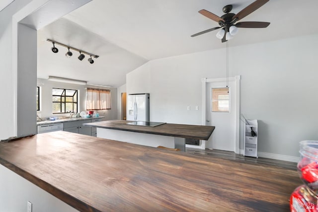 kitchen with gray cabinetry, white appliances, vaulted ceiling, wood counters, and dark hardwood / wood-style floors