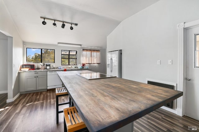 kitchen with white appliances, gray cabinetry, dark hardwood / wood-style flooring, and lofted ceiling