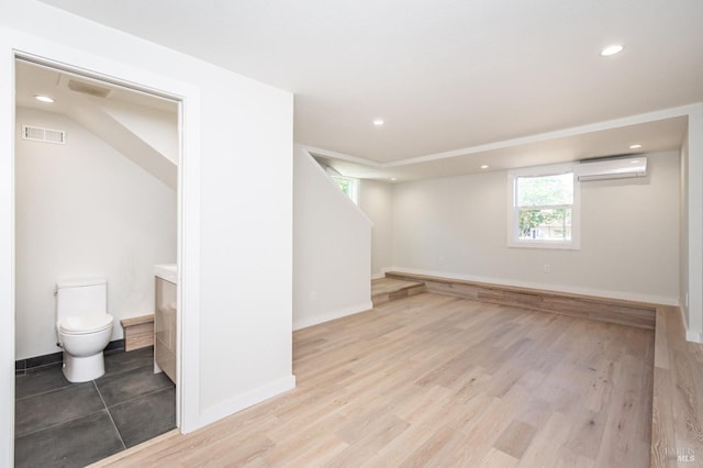 1008 Evans Ave, Napa, CA 94559 - below grade area featuring visible vents, baseboards, wood finished floors, recessed lighting, and a wall unit AC