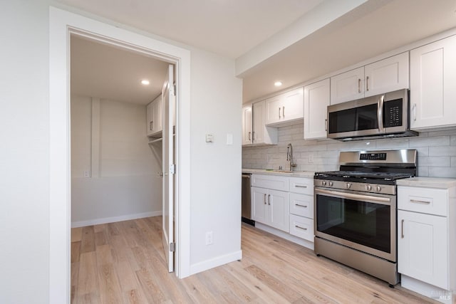 1008 Evans Ave, Napa, CA 94559 - kitchen featuring light countertops, tasteful backsplash, light wood-style flooring, stainless steel appliances, and white cabinets