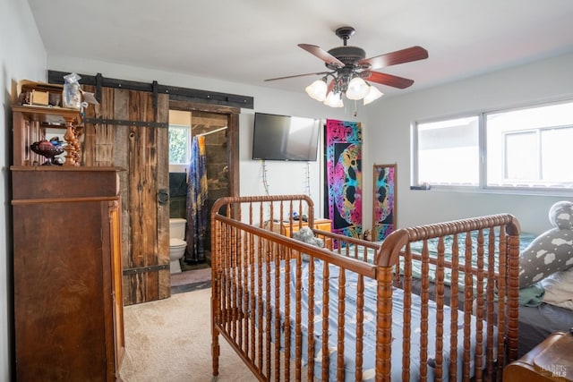 bedroom featuring a barn door, multiple windows, and carpet