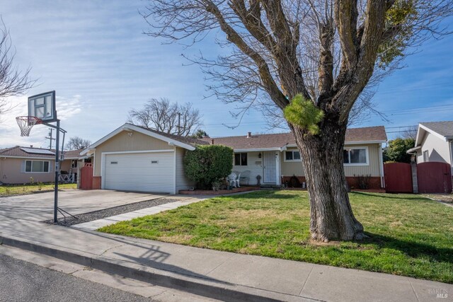 ranch-style home with a front yard, an attached garage, fence, and driveway