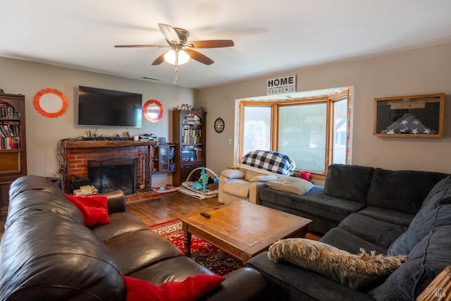 living room featuring a fireplace, a ceiling fan, and wood finished floors