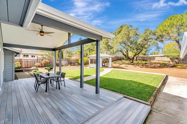 wooden terrace featuring a lawn and ceiling fan