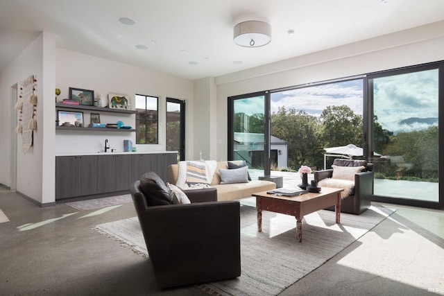 living room featuring finished concrete flooring and baseboards