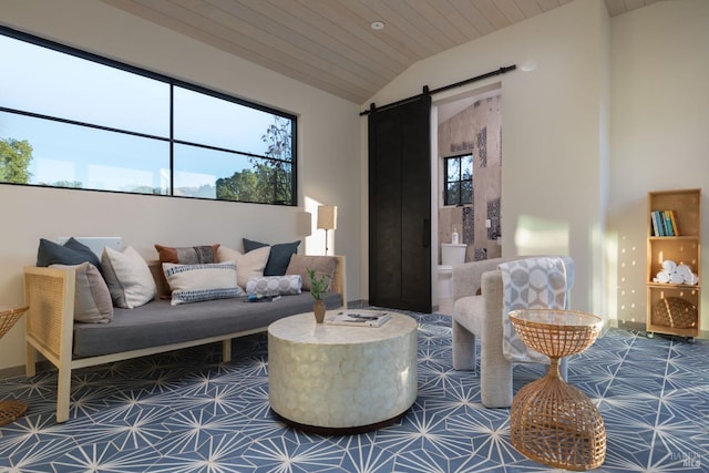 living area with vaulted ceiling, a barn door, wood ceiling, and a healthy amount of sunlight