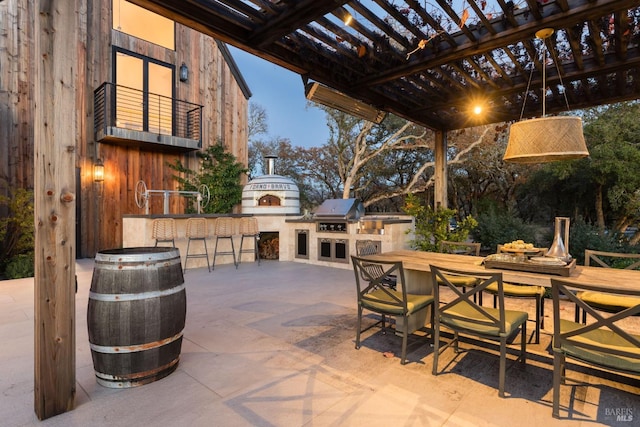 view of patio with outdoor dining space, outdoor dry bar, a pergola, and area for grilling