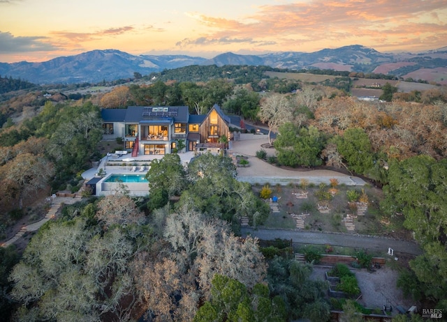 aerial view at dusk featuring a mountain view