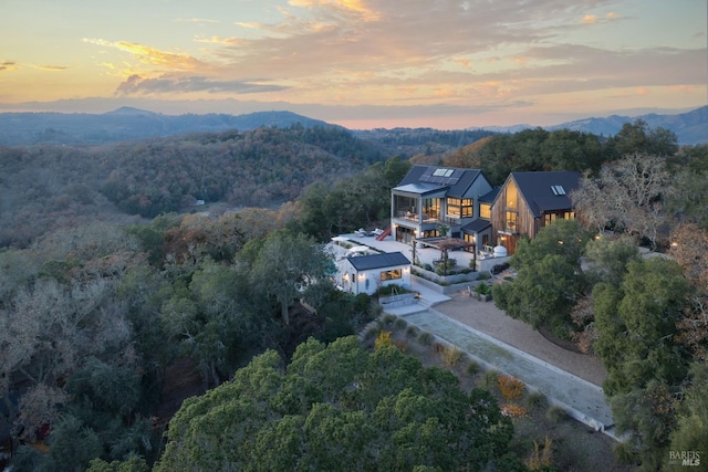 drone / aerial view with a mountain view and a wooded view