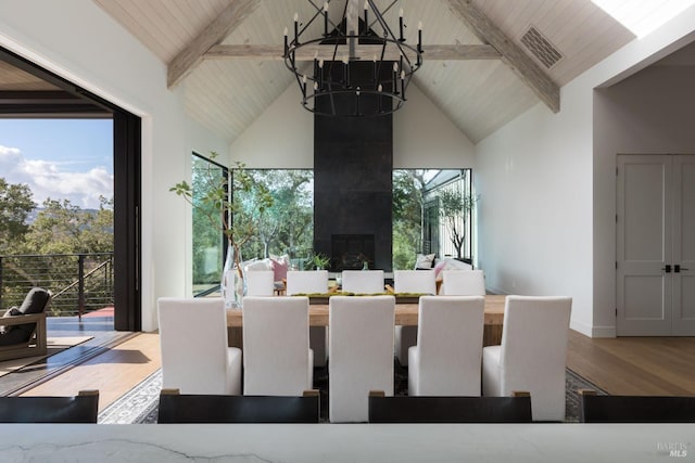 dining room featuring a chandelier, high vaulted ceiling, wood finished floors, visible vents, and beamed ceiling