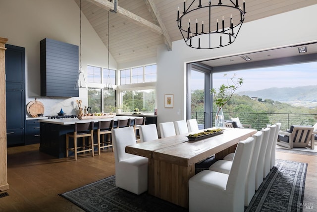 dining area featuring an inviting chandelier, a mountain view, wood finished floors, and beamed ceiling