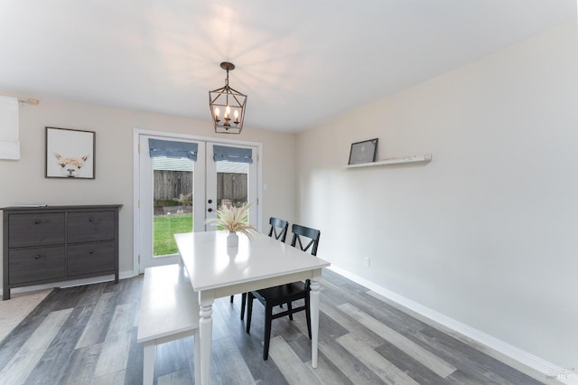 dining area with a chandelier, french doors, baseboards, and wood finished floors