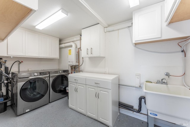 laundry room featuring a sink, washing machine and dryer, tankless water heater, and cabinet space