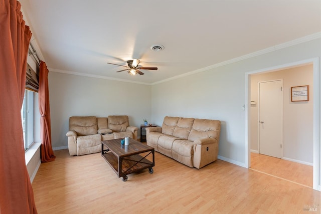 living room with baseboards, light wood-style flooring, visible vents, and crown molding